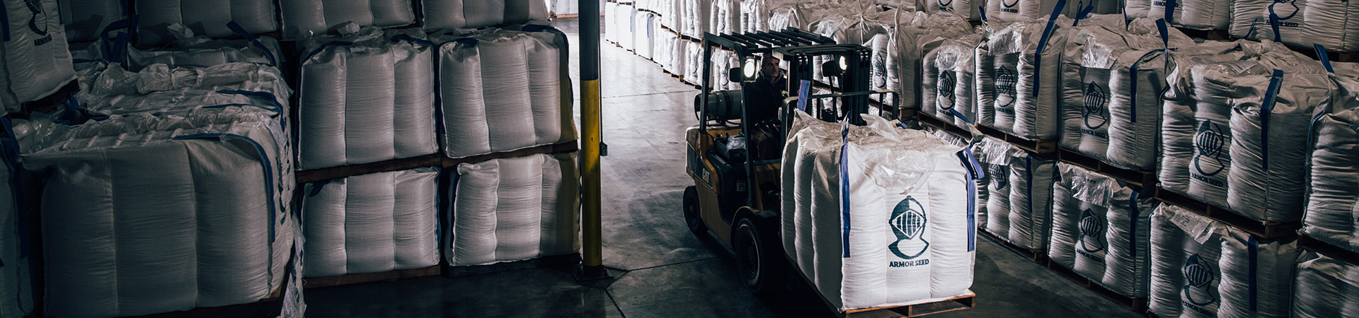 a forklift hauling a pallet of seeds 